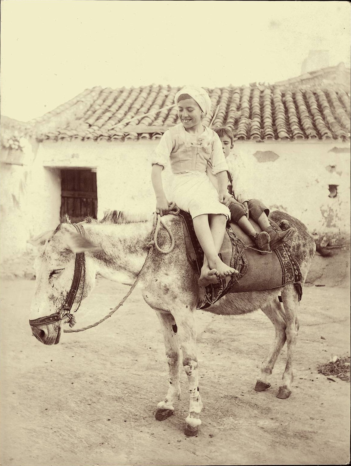 t.-Niños montando en burro en los alrededores de la ciudad