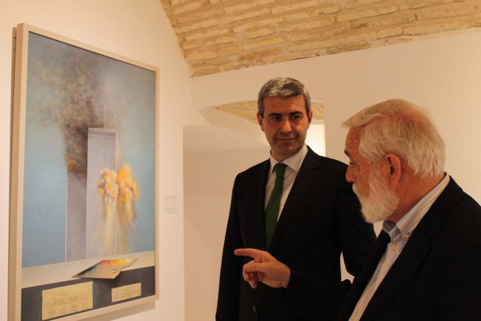 Imagen de Álvaro Gutiérrez y Juan Berenguel ante uno de los realistas cuadros de la exposición