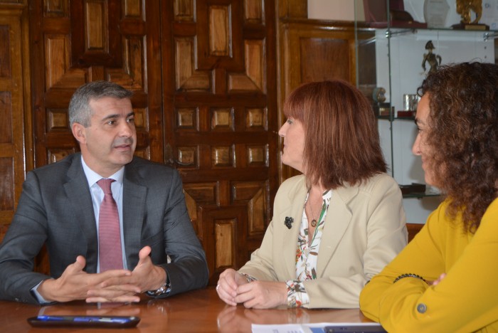 Imagen de Álvaro Gutiérrez charlando con las responsables de ADACE Castilla-La Mancha