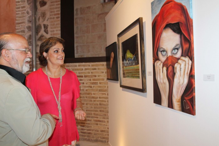 Imagen de María Ángeles García contemplando la exposición junto al organizador Eugenio Fernández