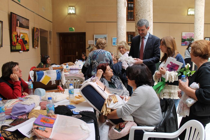 Imagen de Álvaro Gutiérrez contempla un ramo de novia realizado en encaje de bolillos