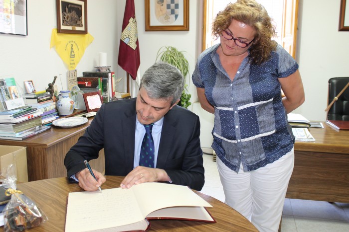 Álvaro Gutiérrez firmando en el Libro de Honor del Ayuntamiento de Parrillas junto a la alcaldesa
