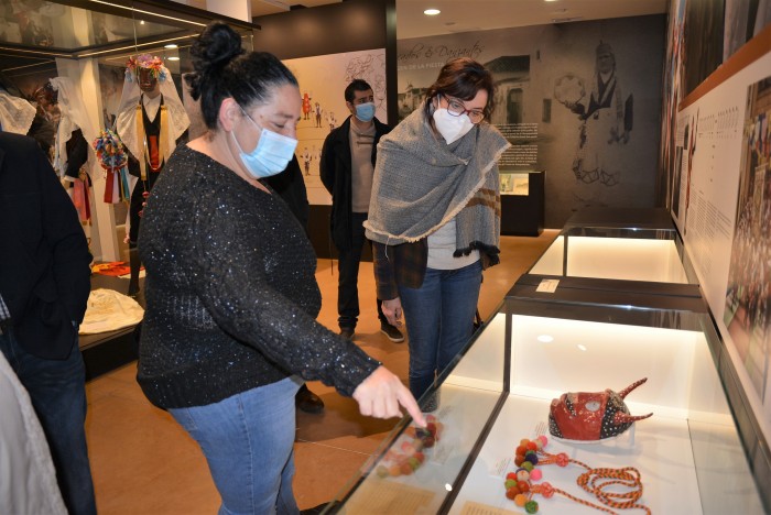 Imagen de Ana Gómez y Carmen Cano contemplando las características máscaras de Pecados y Danzantes