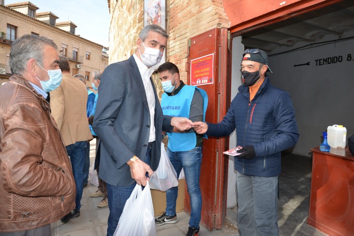 Álvaro Gutiérrez entregando alimentos en la entrada de la plaza de toros de Toledo