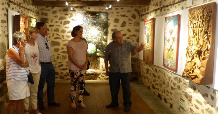 María Ángeles García atiende a las explicaciones de José Camero de su exposición en Melque