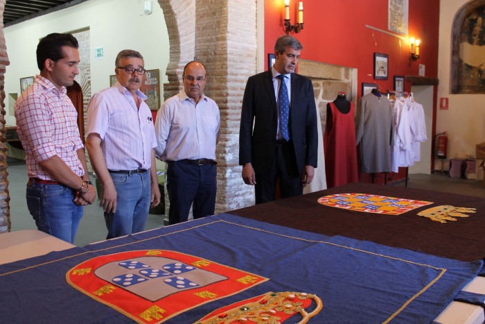 Imagen de Álvaro Gutiérrez junto a los escudos elaborados en el taller de empleo de Oropesa